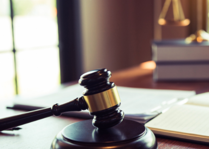 Gavel on desk with law books.