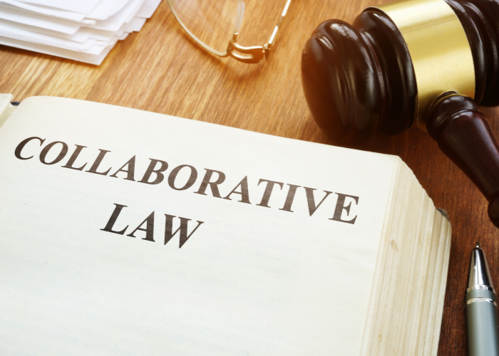 Book open with collaborative law written across page with gavel and glasses on desk