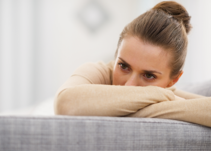 Stressed woman sittin gon couch.