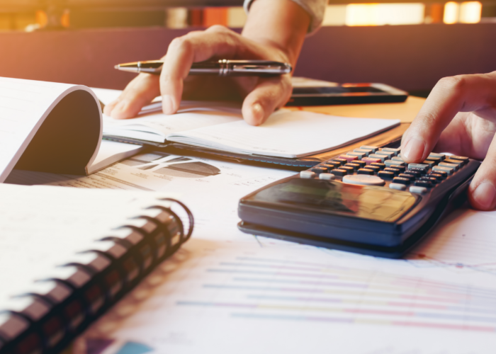 Person calculating finances with calculator