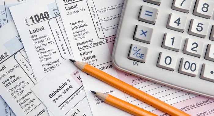 Tax forms with calculator and pencils