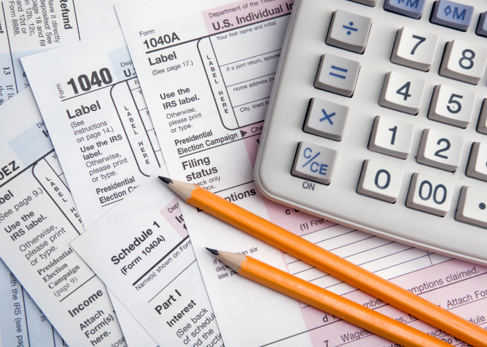 Tax forms with calculator and pencils
