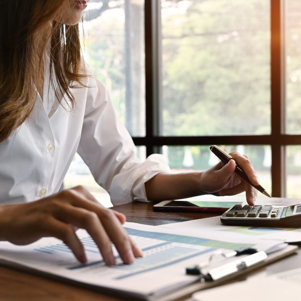 Woman sitting at table calculating bills.