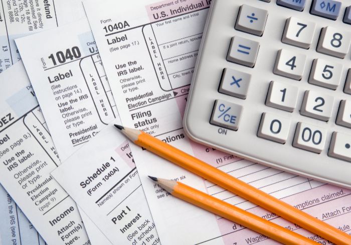 Tax forms with calculator and pencils