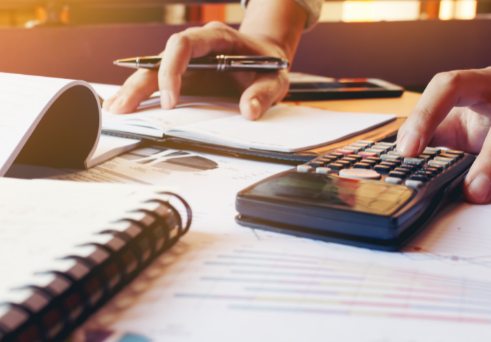 Person calculating finances with calculator
