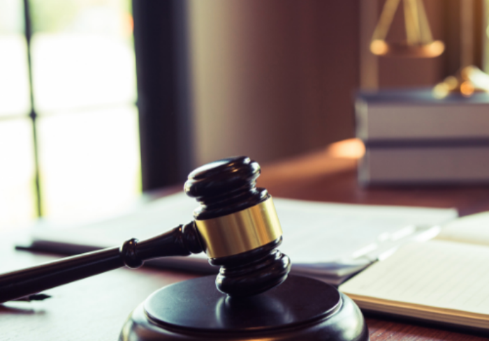 Gavel on desk with law books.