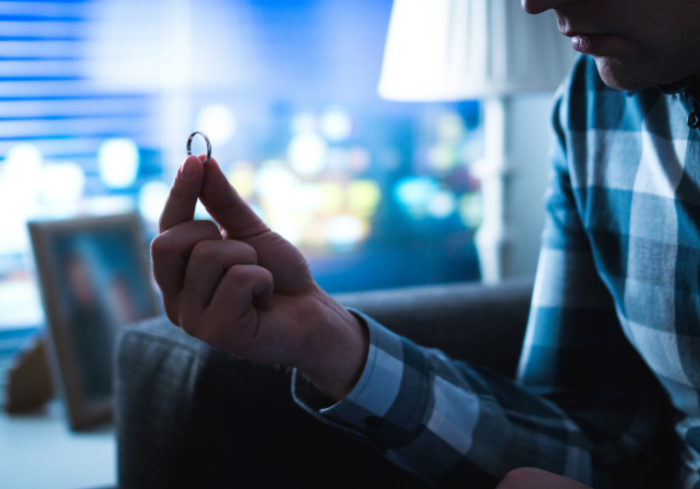 Man sitting down holding wedding ring